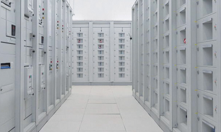 Un corridoio fiancheggiato da file di rack di server bianchi in un centro dati o in una sala server ben illuminati.